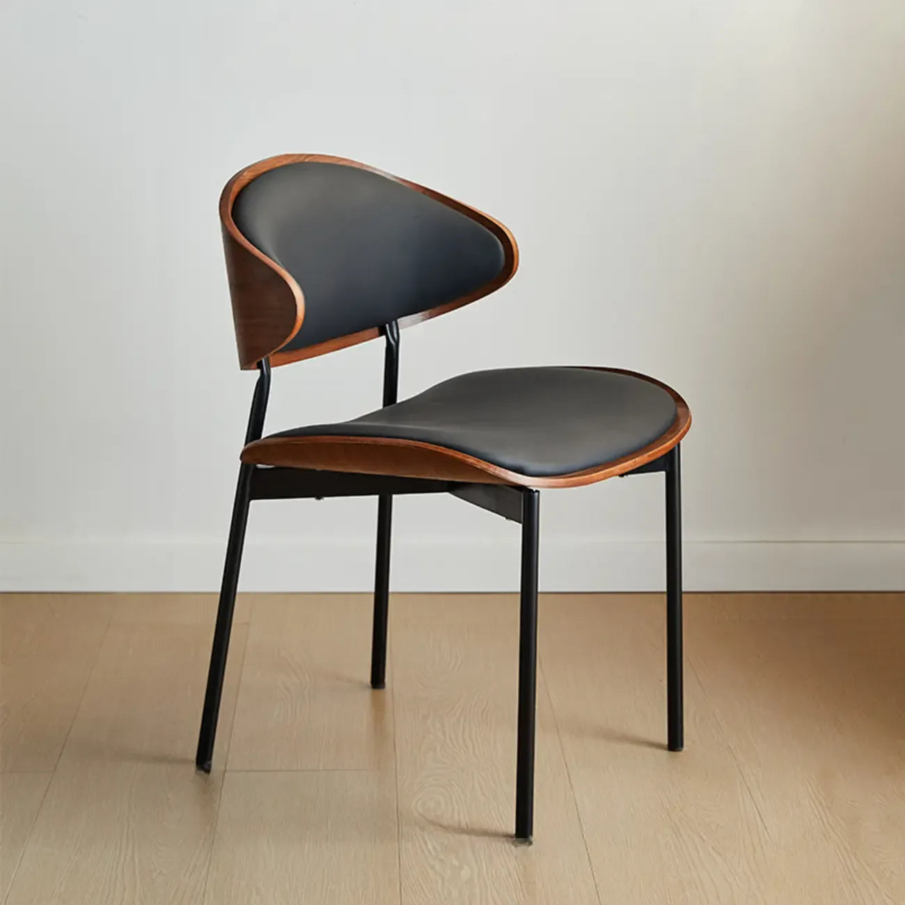 Chaise de salle à manger à dossier incurvé et assise en cuir noir