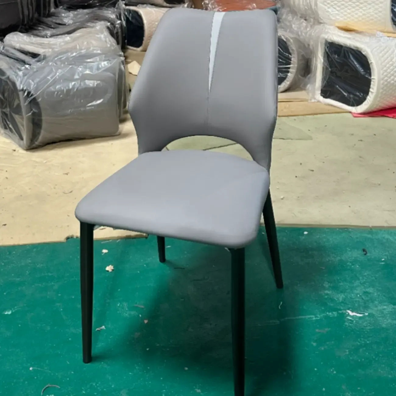 Chaise de salle à manger moderne sans accoudoirs, dossier ouvert, en similicuir.